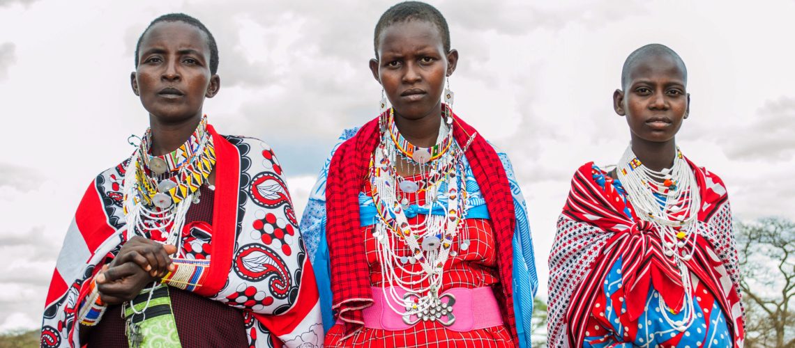 Trois femmes Maasaïs revêtues de leur tenue traditionnelle et de colliers divers